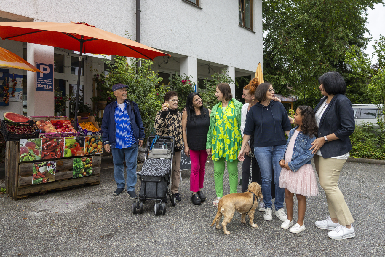 Eine Gruppe von Stadtteilbewohner:innen vor einem Obststand